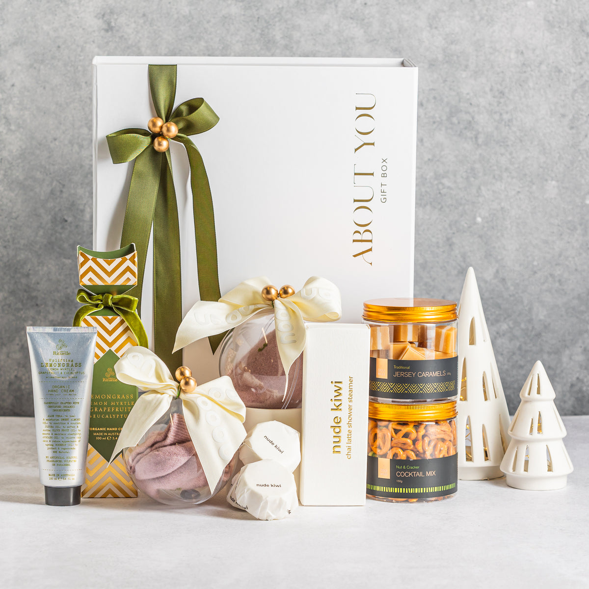 Christmas pamper gift box with clear baubles with Nooan Socks, lemongrass hand cream, shower steamers, caramels and cocktail snack mix
