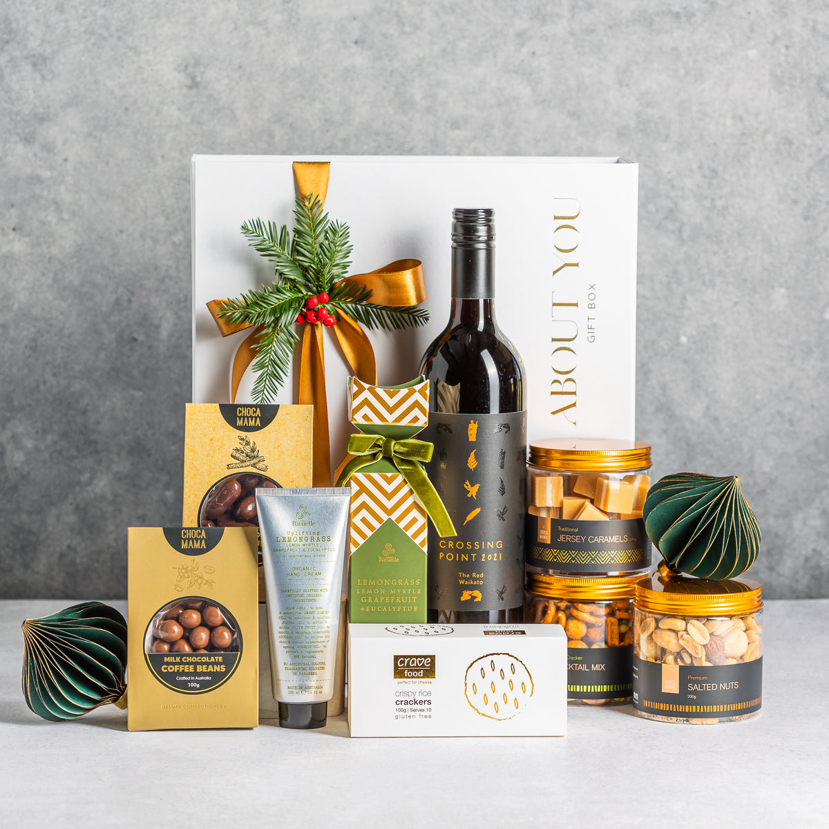 Christmas Uncorked gift box with red wine, chocolates, hand cream, crackers and snack jars, styled with gold ribbon