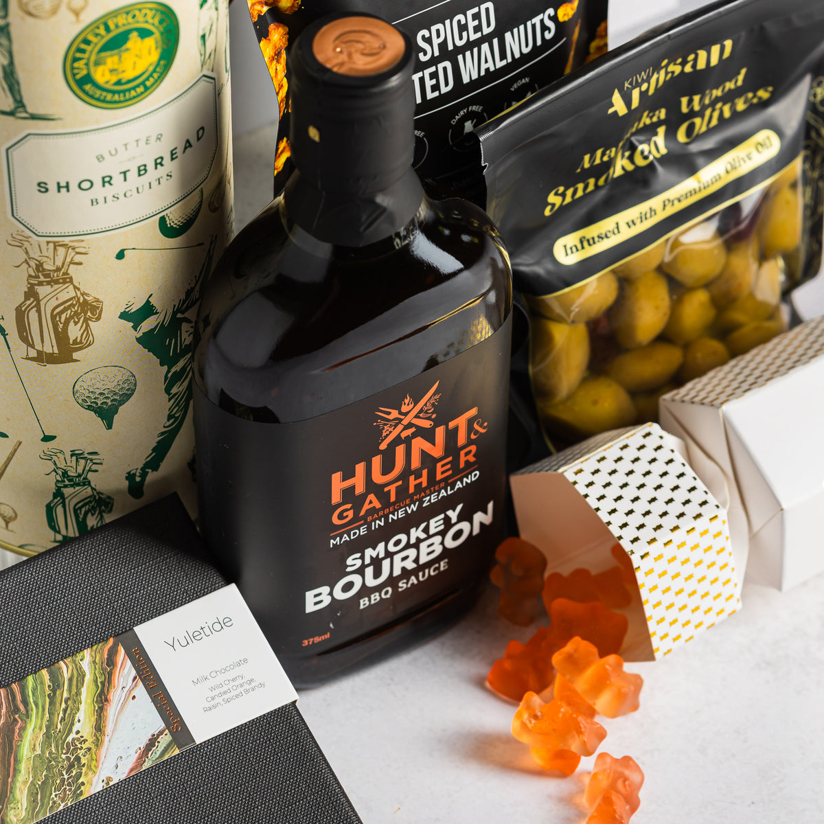 New Zealand-made Hunt & Gather smoky bourbon BBQ sauce beside smoked olives, shortbread and Yuletide chocolate